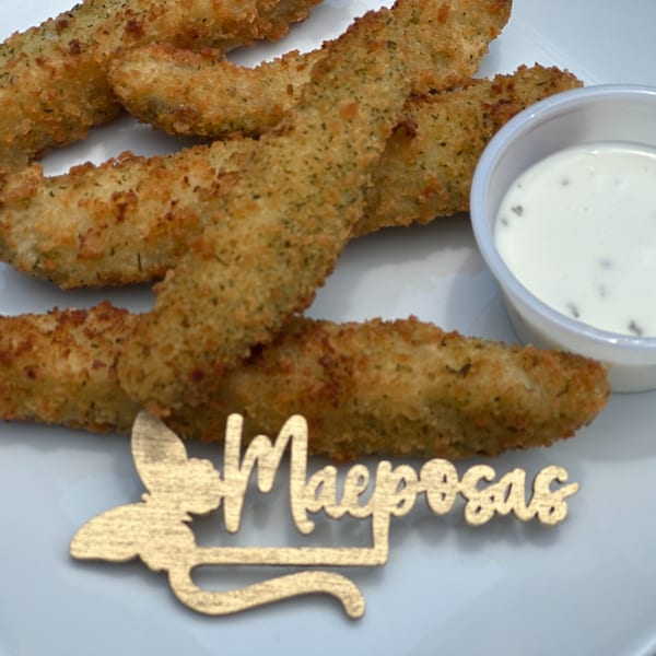 Crispy fried pickle spears with a side of ranch dressing and a Maeposas logo.